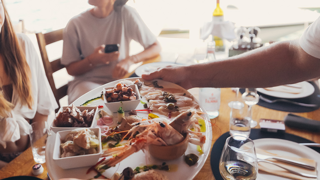 A chef's tasting platter of fresh Adriatic seafood and local products with white wine