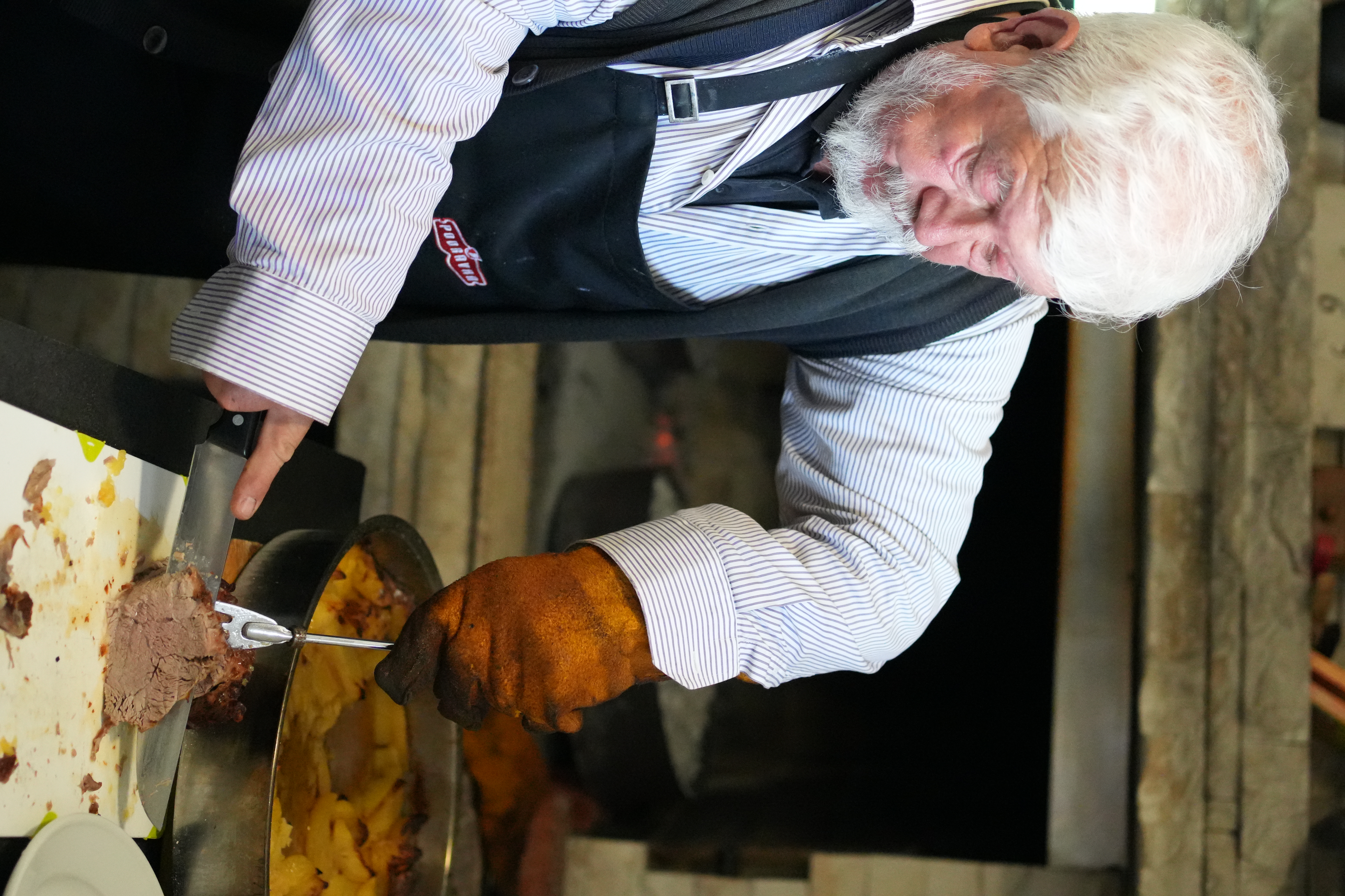 Family farm owner preparing slices of meat for his food tasting group