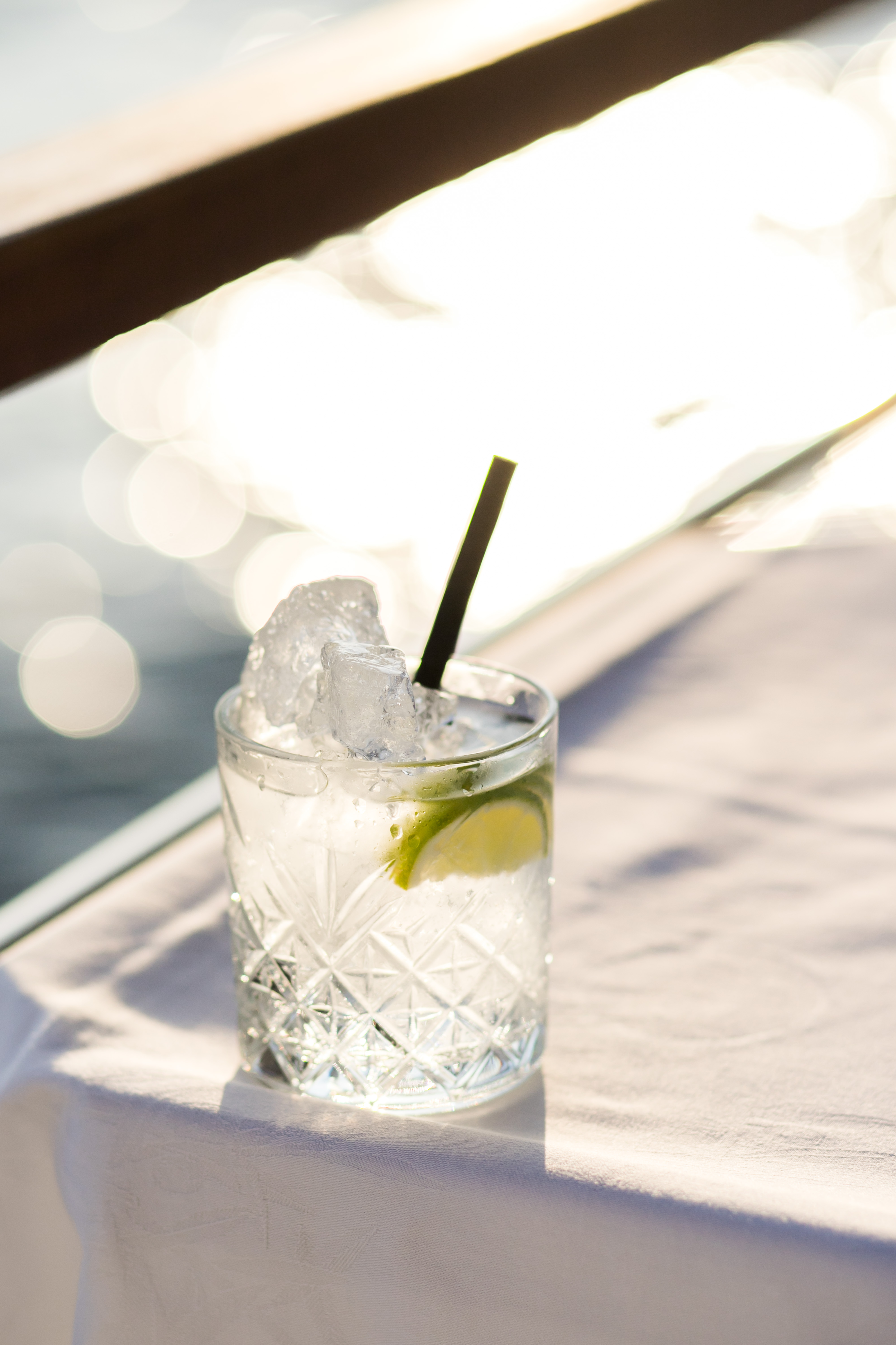 A crystal-cut cocktail with lime on a sunlit Adriatic terrace