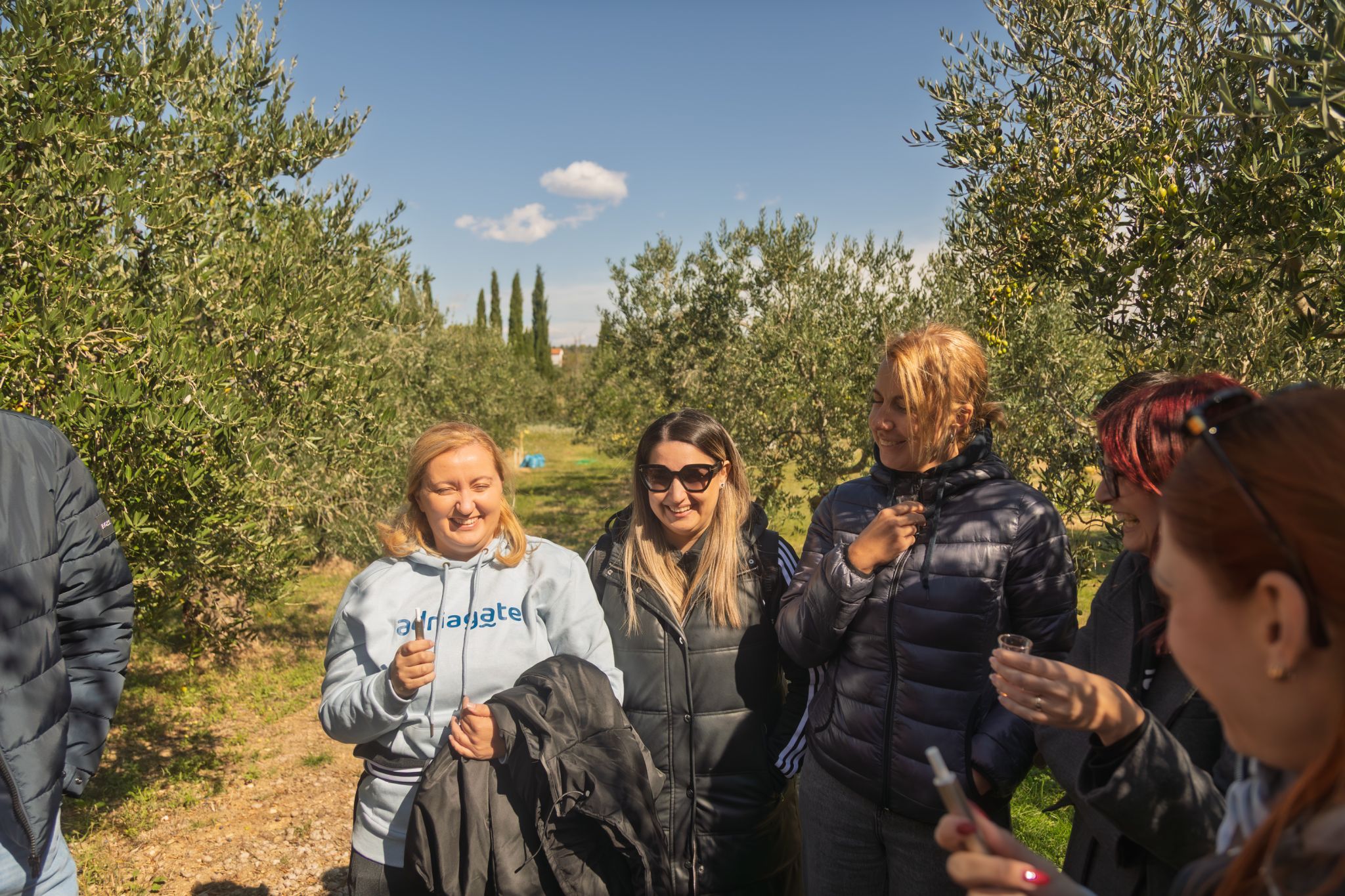 Adriagate guests laughing while tasting homemade liqueur at a family farm