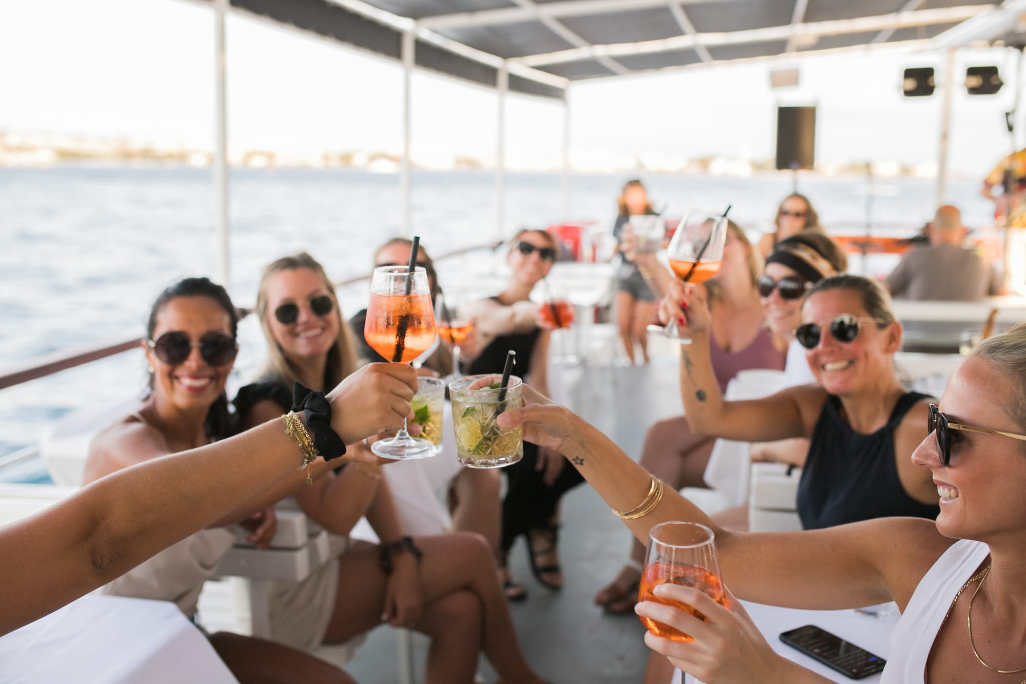 A group of friends toasting on an Authland boat tour along the Croatian Adriatic at golden hour
